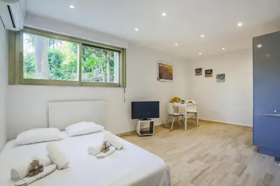 a bedroom with a white bed and a television at Studio AC 