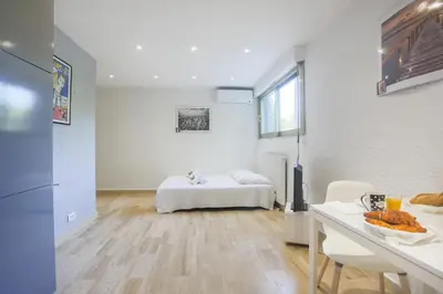 a white room with a bed and a table at Studio AC 