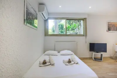 a white bedroom with a bed and a window at Studio AC 