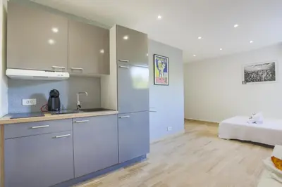 a kitchen with blue cabinets and a bed in a room at Studio AC 