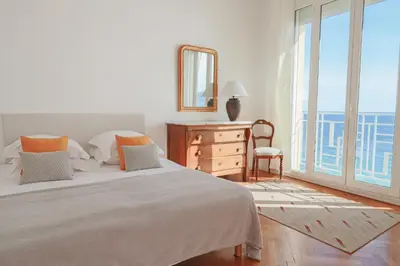 a bedroom with a bed and a mirror and a window at Charming Apartment on Seafront with Rooftop in Cannes