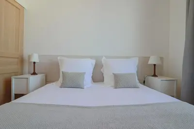 a bedroom with a white bed with two lamps at Charming Apartment on Seafront with Rooftop in Cannes
