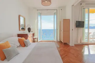 a bedroom with a bed and a view of the ocean at Charming Apartment on Seafront with Rooftop in Cannes