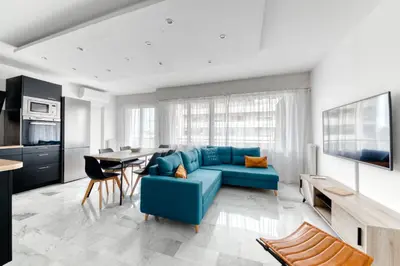 a living room with a blue couch and a table at 4P Modern & Secured Parking in Le Cannet