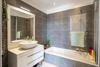 a bathroom with a sink and a tub and a mirror at LE BOREAL penthouse avec terrasse et vue panoramique spectaculaire sur la ville in Cannes