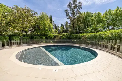 a swimming pool in a yard with a fence at LE BOREAL penthouse avec terrasse et vue panoramique spectaculaire sur la ville in Cannes