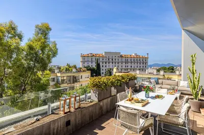 a balcony with a table and chairs and a view of a building at LE BOREAL penthouse avec terrasse et vue panoramique spectaculaire sur la ville in Cannes