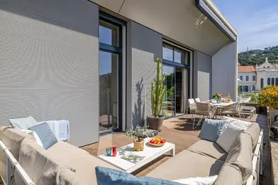 a patio with a couch and a table on a balcony at LE BOREAL penthouse avec terrasse et vue panoramique spectaculaire sur la ville in Cannes