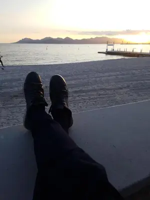 a person sitting on the beach looking at the ocean at ++++ renovated cosy 50m2 sunny flat / balcony / close to beach and to the Palais des festivals ++++ in Cannes
