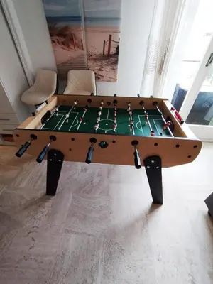 a ping pong table in the middle of a room at ++++ renovated cosy 50m2 sunny flat / balcony / close to beach and to the Palais des festivals ++++ in Cannes