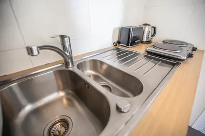 a stainless steel sink in a small kitchen at ++++ renovated cosy 50m2 sunny flat / balcony / close to beach and to the Palais des festivals ++++ in Cannes