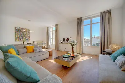 a living room with a couch and a table at IMMOGROOM - Magnificent 180m duplex apartment - Parking - Air conditioning in Cannes