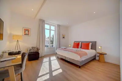 a bedroom with a bed with orange pillows and a desk at IMMOGROOM - Magnificent 180m duplex apartment - Parking - Air conditioning in Cannes