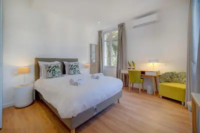 a bedroom with a large white bed and a desk at IMMOGROOM - Magnificent 180m duplex apartment - Parking - Air conditioning in Cannes