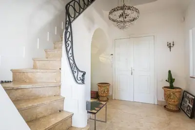 a staircase in a home with a chandelier at Art Deco Luxury Apartment with Breath Taking View on Cannes Bay by Olidesi in Cannes