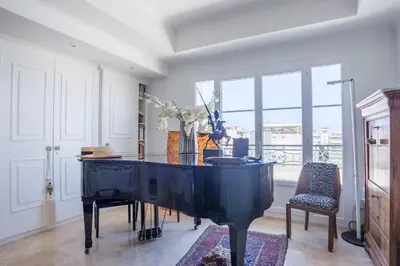 a large black piano in a room with windows at Art Deco Luxury Apartment with Breath Taking View on Cannes Bay by Olidesi in Cannes