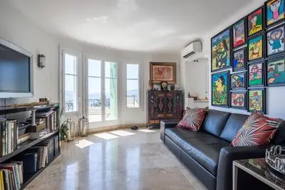 a living room with a couch and a tv at Art Deco Luxury Apartment with Breath Taking View on Cannes Bay by Olidesi in Cannes