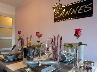 a table with red roses and plates and glasses on it at Cannes Center in Cannes
