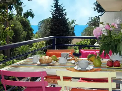 a table with a plate of food on a balcony at Cannes Plage in Cannes
