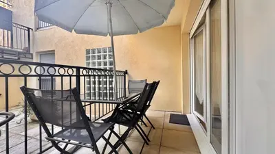 a table and chairs on a balcony with an umbrella at Palazzio 2, by Welcome to Cannes in Cannes