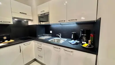 a kitchen with white cabinets and a sink at Palazzio 2, by Welcome to Cannes in Cannes