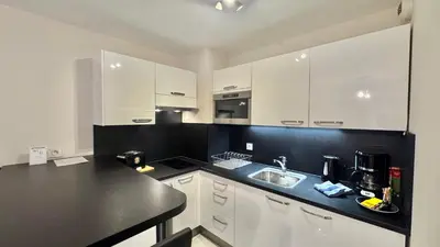 a kitchen with white cabinets and a black counter top at Palazzio 2, by Welcome to Cannes in Cannes