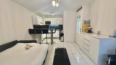 a small white kitchen with a table in a room at Palazzio 2, by Welcome to Cannes in Cannes