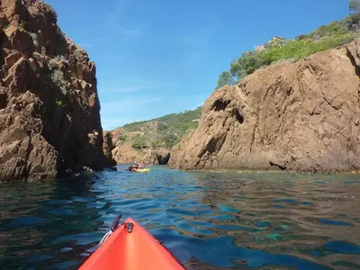 a red kayak in the water next to some rocks at Mimosa in Cannes