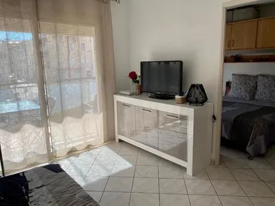 a bedroom with a television on a dresser with a bed at Mimosa in Cannes