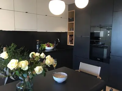 a kitchen with a table with a vase of roses on it at Bleu Regard in Cannes