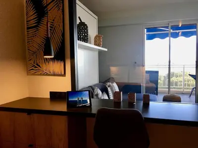 a living room with a desk with a laptop on it at Bleu Regard in Cannes