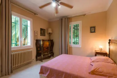a bedroom with a bed and two windows at Villa Tsavorite - Cannes Californie in Cannes