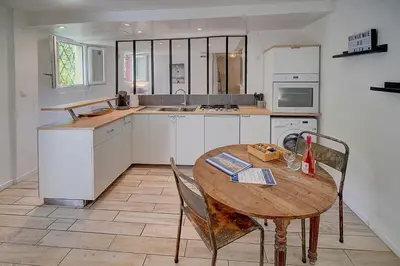 a kitchen with a wooden table and a table and chairs at Le Alex - 800m des plages - extérieur - Verrière Côte d'Azur in Cannes