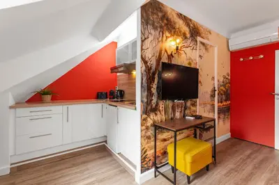 a kitchen with white cabinets and a red wall at Le Carnot - HYPERCENTRE - Cosy & Climatisation in Cannes