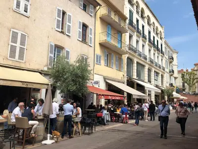 a group of people walking down a street with buildings at 2P 40m2 -Cannes centre- Palais des festivals - in Cannes