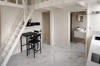 a kitchen with a staircase and a table and chairs at Studio chic rénové à 5 min du Palais & de la Croisette Cannes in Cannes
