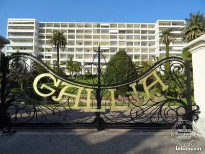 a metal bench in front of a large building at Studio chic rénové à 5 min du Palais & de la Croisette Cannes in Cannes