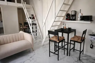 a living room with a table and chairs and a couch at Studio chic rénové à 5 min du Palais & de la Croisette Cannes in Cannes