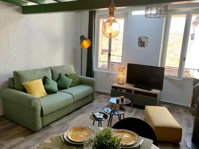 a living room with a green couch and a tv at Maison de village Cannes Le Suquet in Cannes