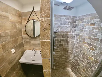 a bathroom with a sink and a shower with a mirror at Maison de village Cannes Le Suquet in Cannes