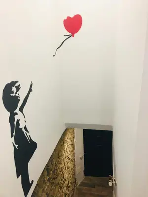 a wall mural of a woman with a heart balloon at Maison de village Cannes Le Suquet in Cannes