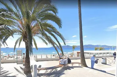 a group of people sitting on a bench near the beach at Maison de village Cannes Le Suquet in Cannes