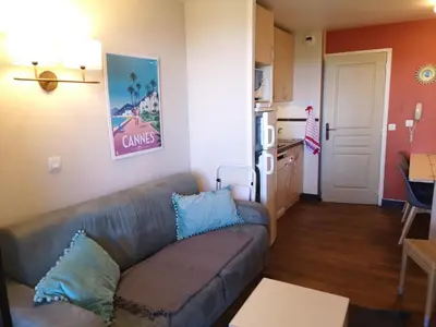a living room with a couch and a kitchen at Flo & Rose Azur - Duplex vue mer terrasses piscine jardins parking in Cannes