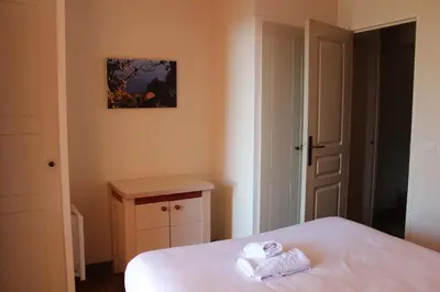 a bedroom with a bed with two towels on it at Flo & Rose Azur - Duplex vue mer terrasses piscine jardins parking in Cannes
