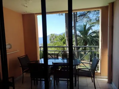 a dining room with a table and chairs and a large window at Flo & Rose Azur - Duplex vue mer terrasses piscine jardins parking in Cannes