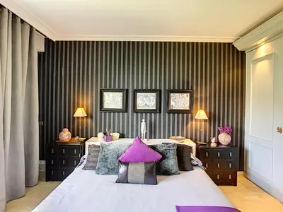 a bedroom with a large bed with purple pillows at FRGK 