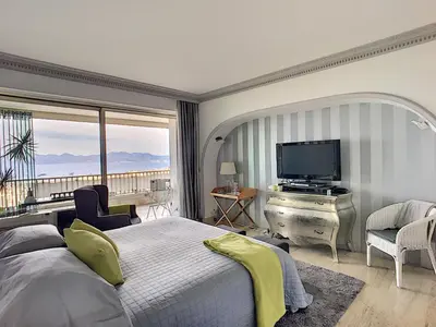 a bedroom with a bed and a television and a balcony at FRGK 