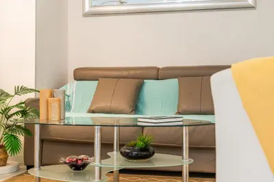 a couch in a living room with a glass table at Palm Beach - swimming pool - beach at few steps in Cannes