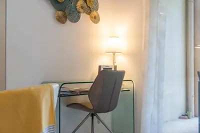 a glass desk with a chair and a lamp at Palm Beach - swimming pool - beach at few steps in Cannes