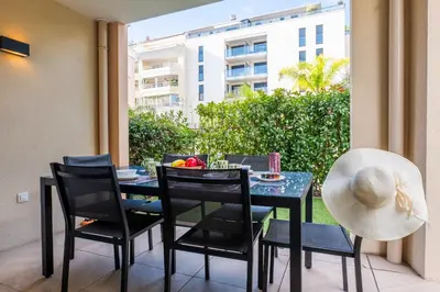a black table and chairs with a bowl of fruit on it at Palm Beach - swimming pool - beach at few steps in Cannes